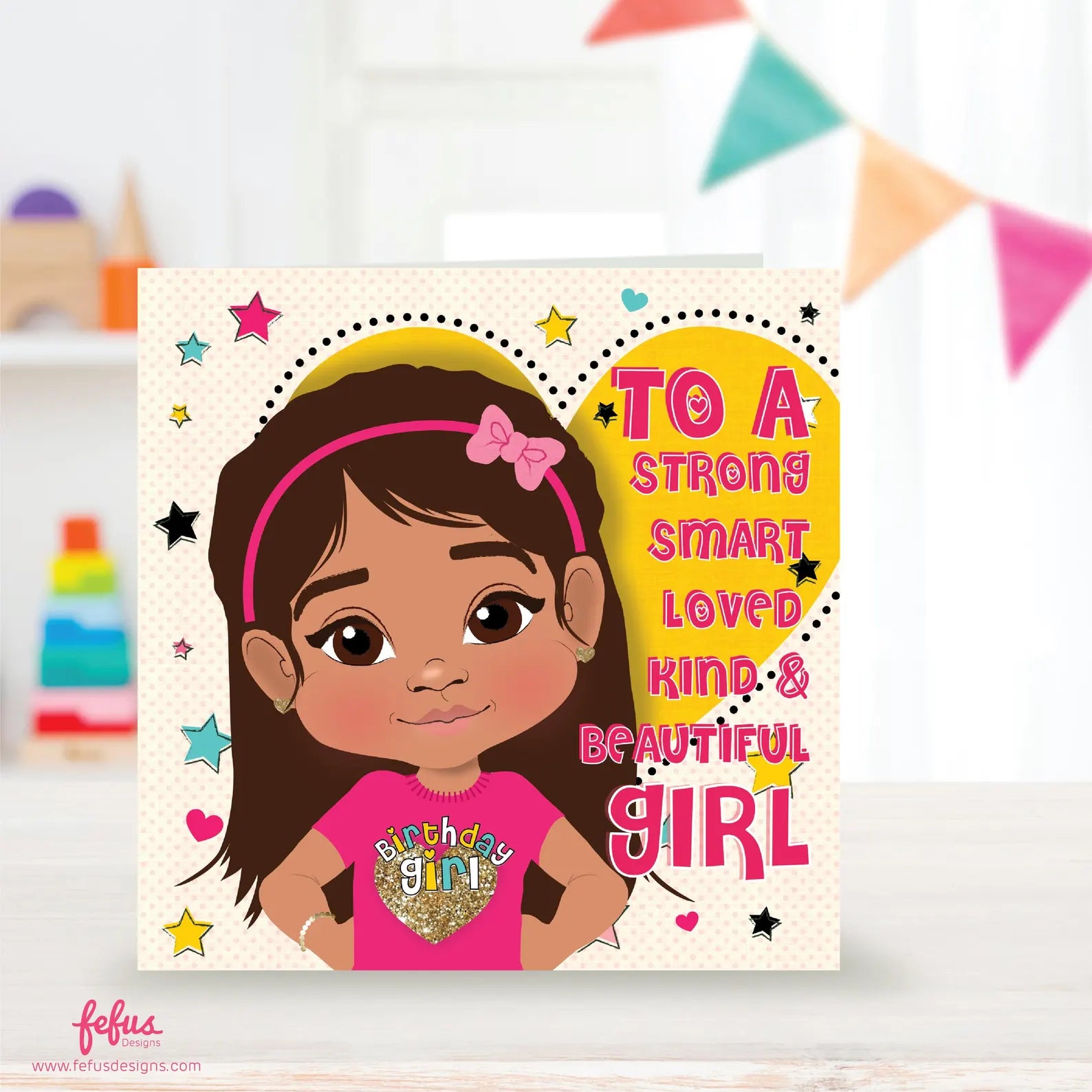A vibrant birthday card featuring a young Latina girl with straight hair and a headband. The girl is wearing a pink top with a gold heart, and the background is a large yellow heart with multi-coloured stars and hearts.
