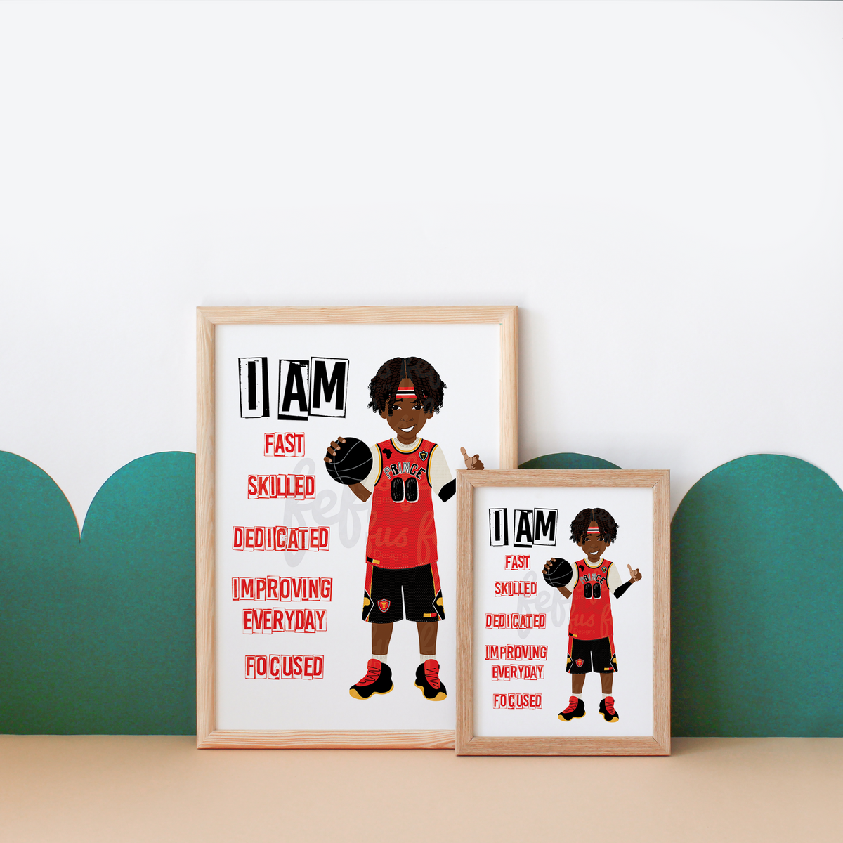 Two framed basketball-themed motivational posters displayed on a beige surface against a white wall with teal scalloped wall decals. The larger poster shows a cartoon basketball player in a red jersey holding a ball, with text reading 'I AM FAST SKILLED DEDICATED IMPROVING EVERYDAY FOCUSED.